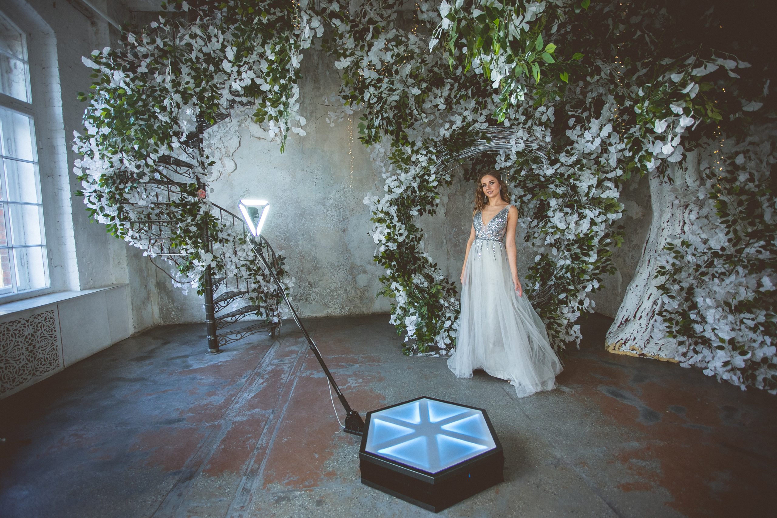 Bride on a 360 photo booth platform in a floral setting