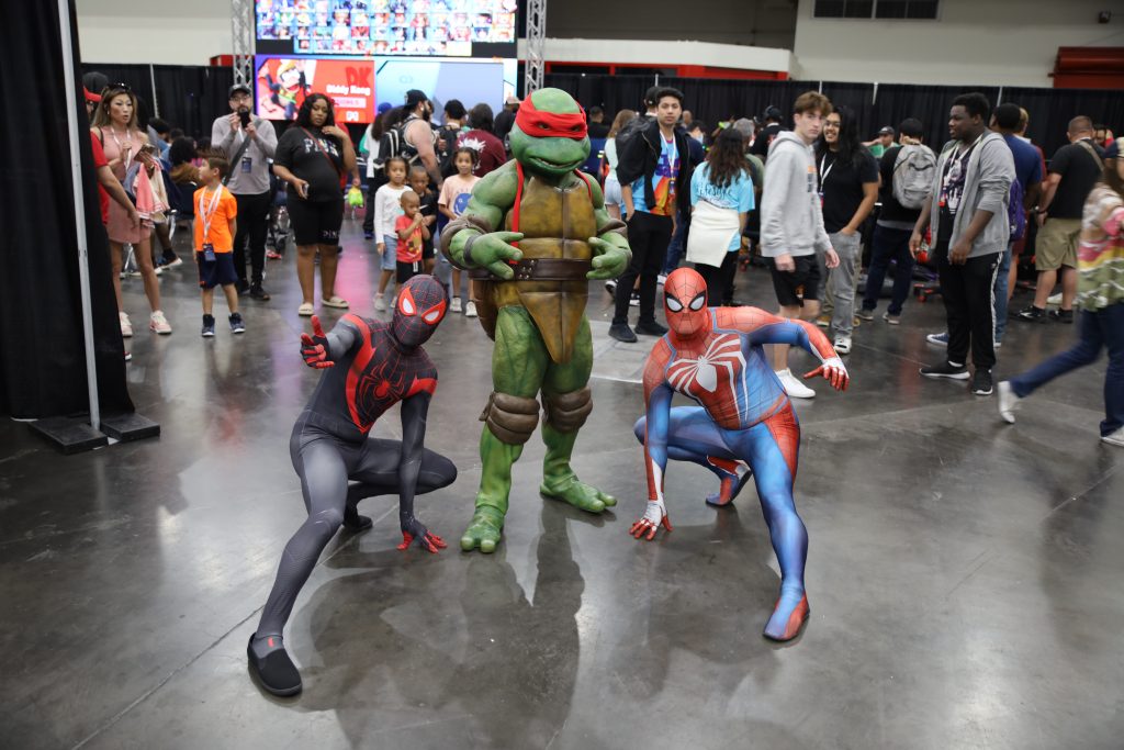 Spider-Man and Ninja Turtle cosplayers at a convention Flashbar activation