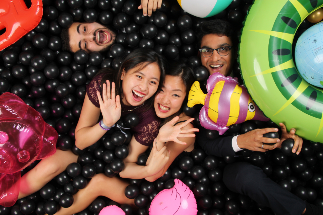 Friends posing with inflatables in a Flashbar ball pit photo booth, overhead view