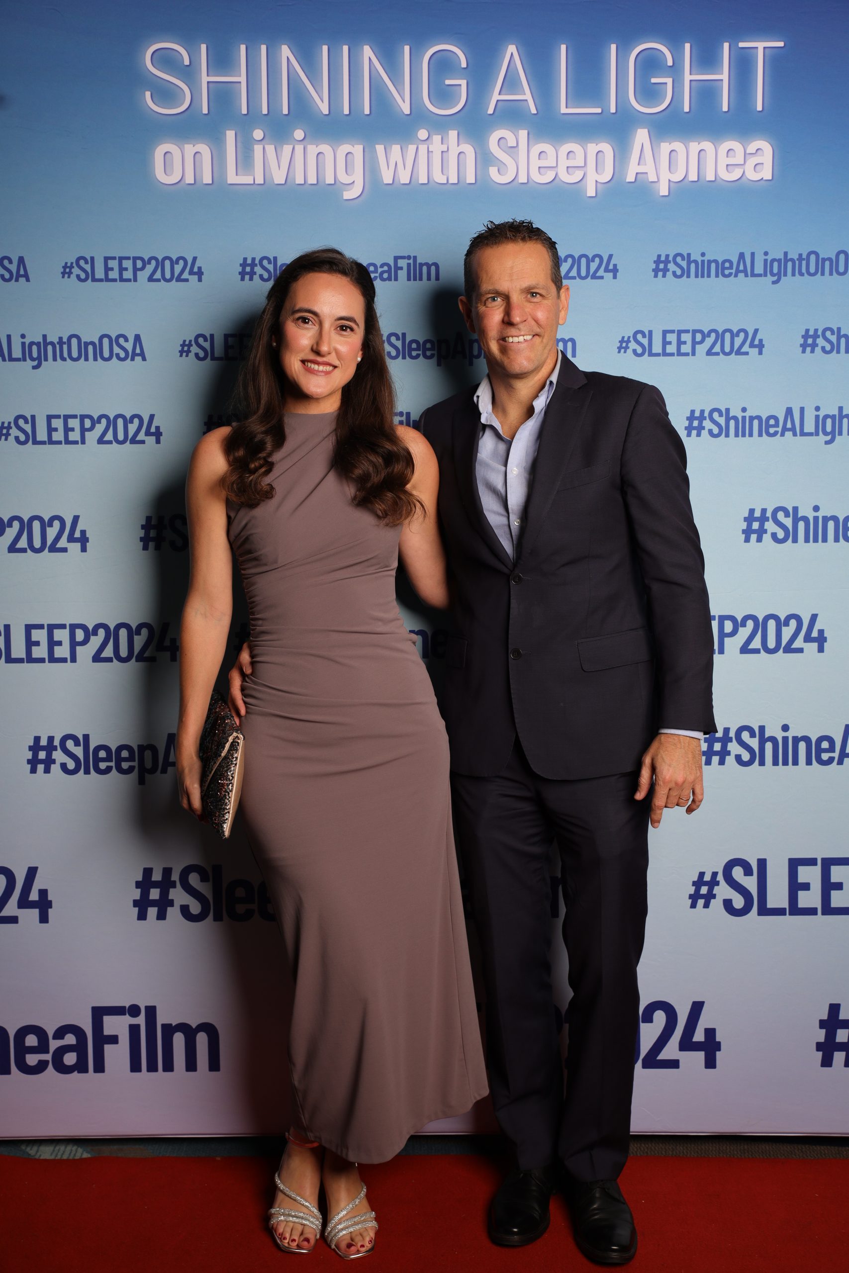 Couple posing at a Sleep Apnea awareness event photo booth backdrop