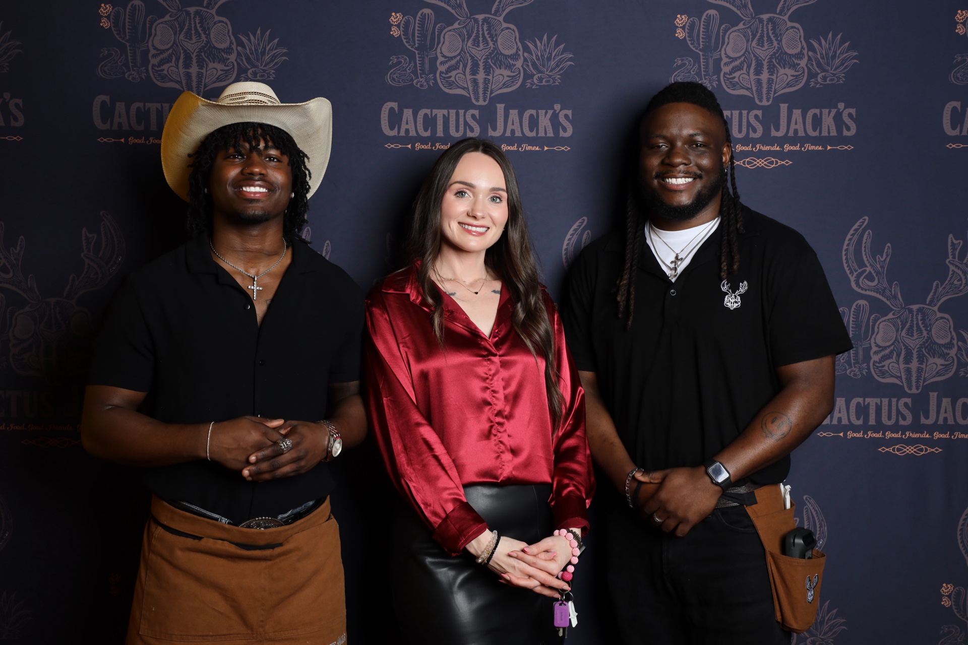 Guests posing at a Cactus Jack's branded photo booth backdrop
