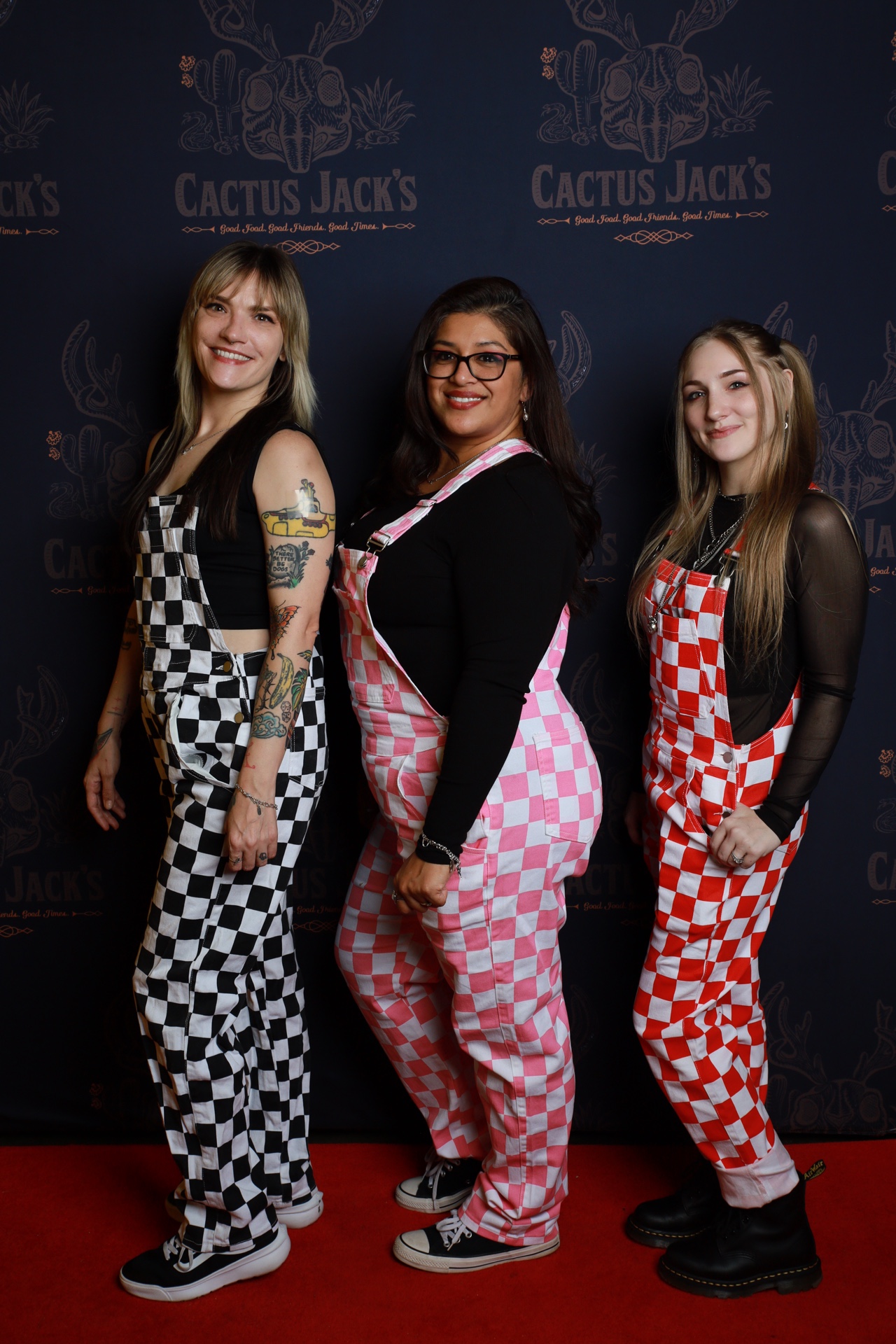 Three guests in themed outfits at a Cactus Jack's photo booth